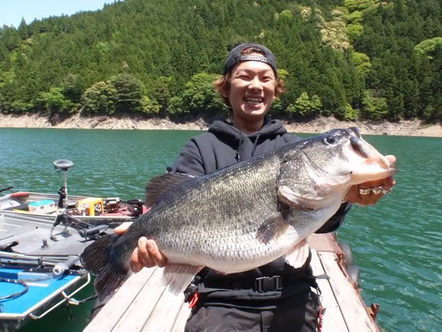 釣り上げたブラックバスを持つモリタク